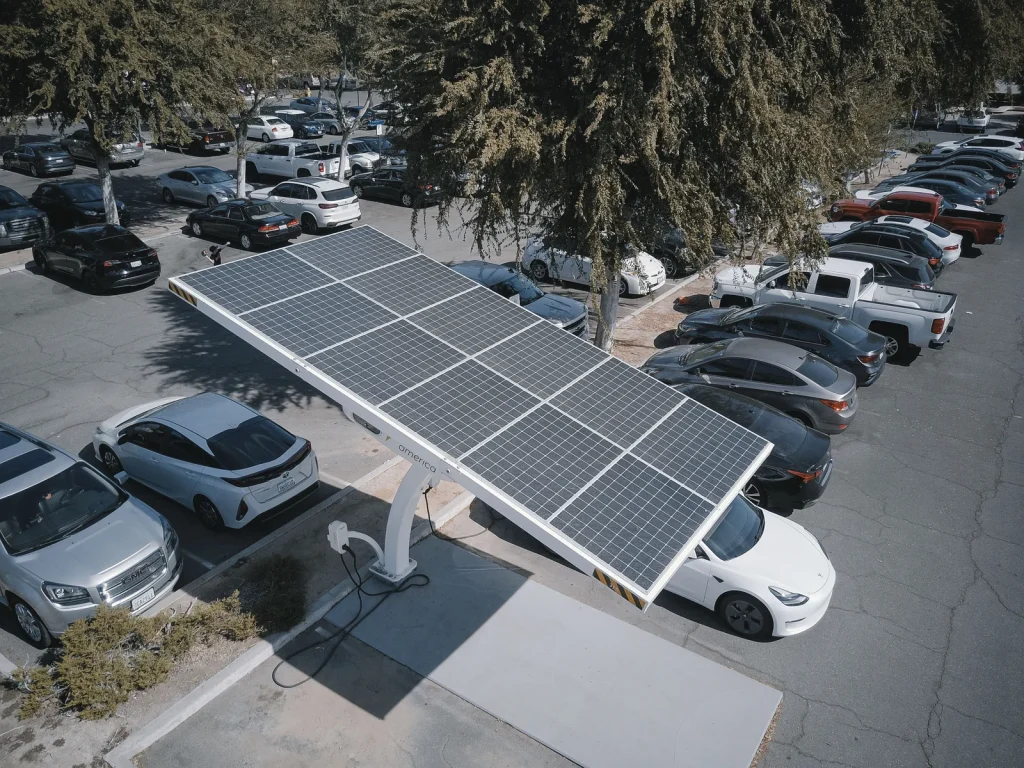Estrutura de painéis solares sobre estacionamento com carro elétrico carregando