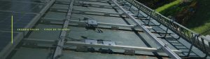Trilho de alumínio, grampos de fixação e cabeamento sobre a estrutura de um telhado com módulos fotovoltaicos