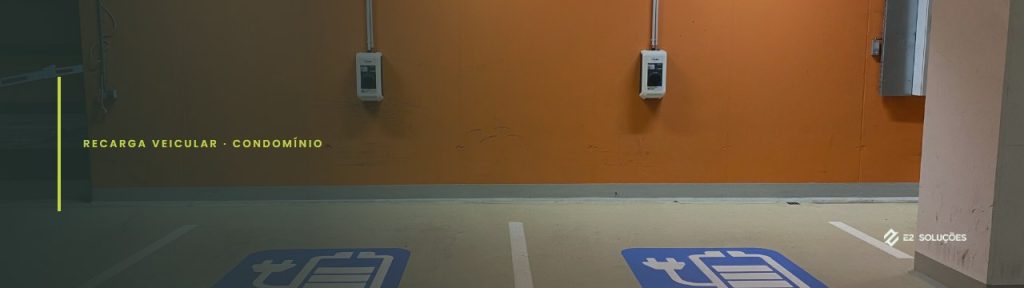 Duas estações de recarga na parede de uma garagem de prédio, com duas vagas demarcadas